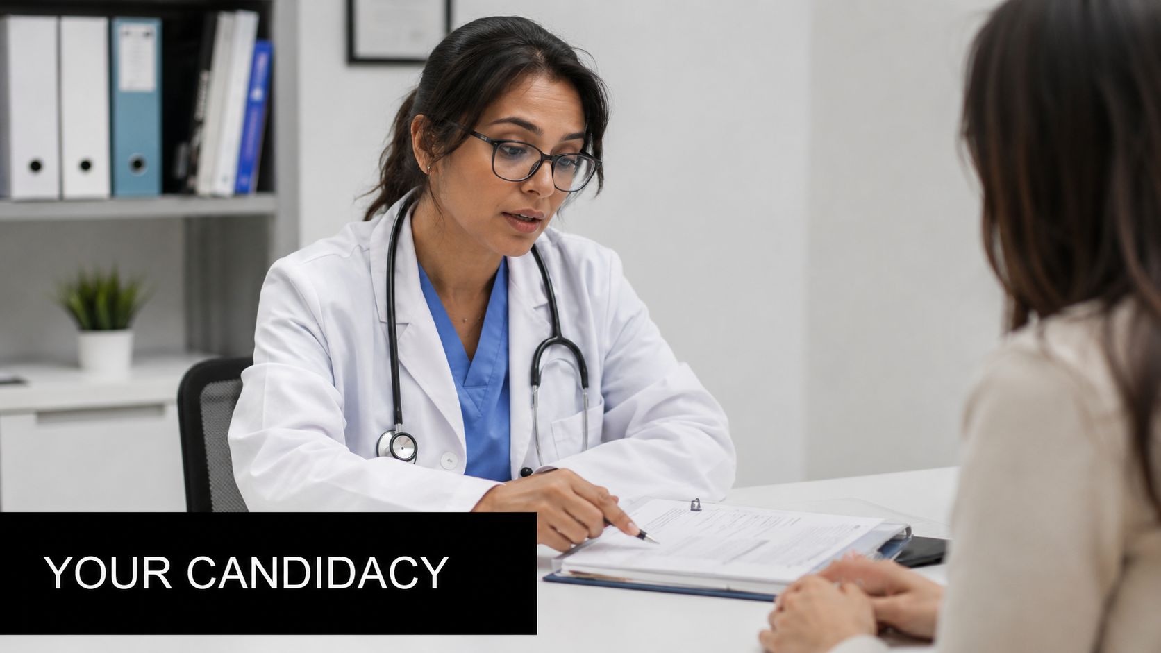 A female doctor with a stethoscope discusses a medical document with a patient in an office.