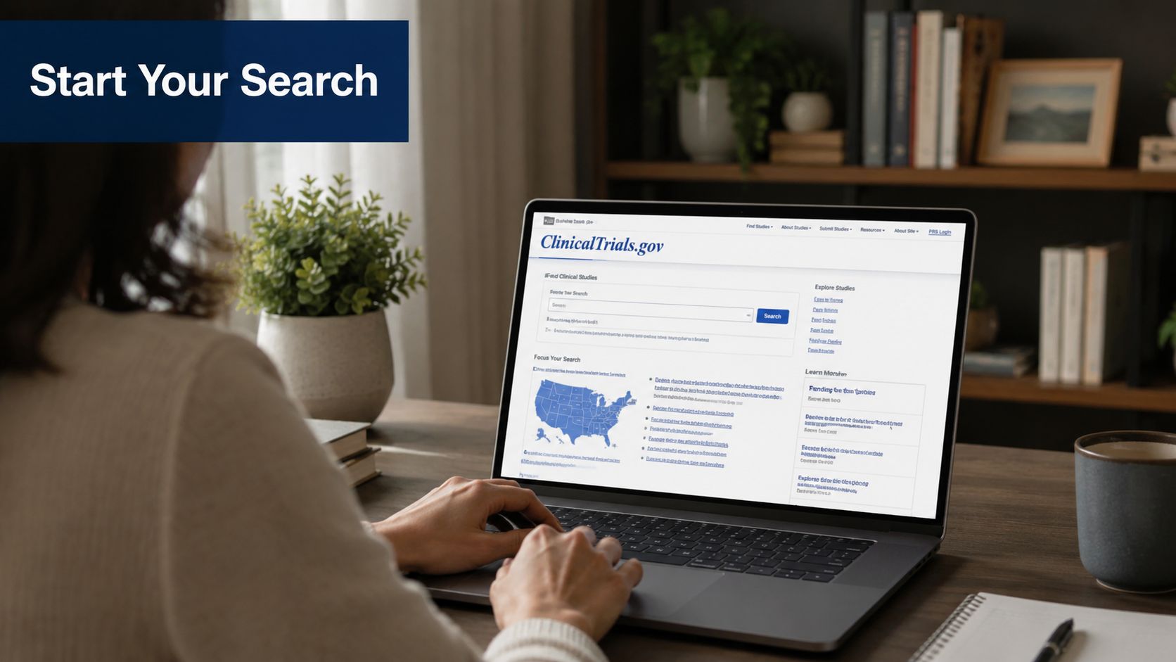 A person sitting at a wooden desk using a laptop to search the ClinicalTrials.gov website for information.