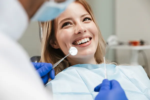 Dental professionals in scrubs and gloves performing a procedure.