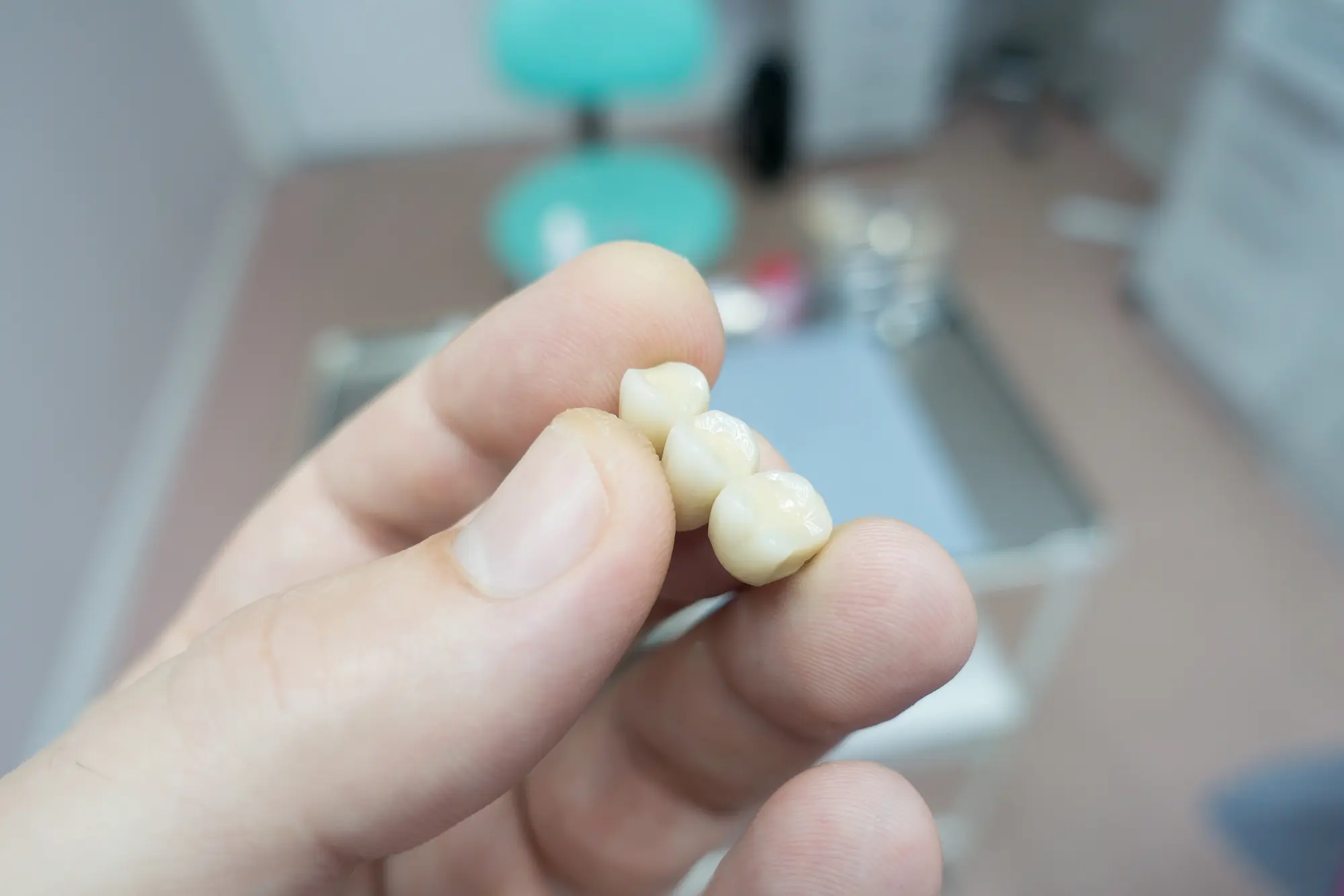 gloved hand holding a dental bridge