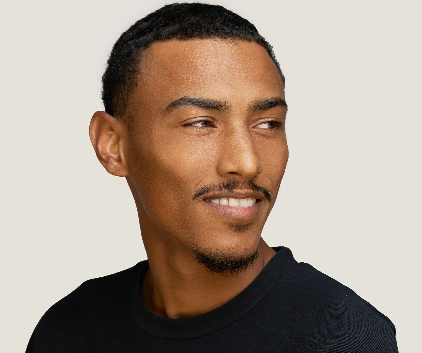 Young man with smooth, radiant skin with a reduced appearance of pores.