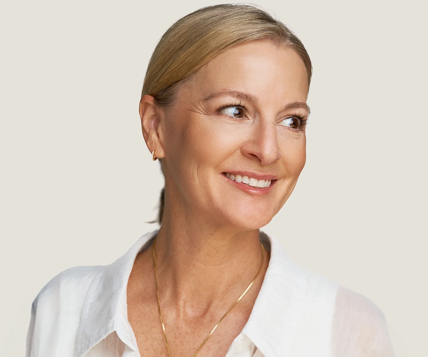 Middle-aged woman with firm, smooth skin that is free of noticeable sun damage or age spots. 