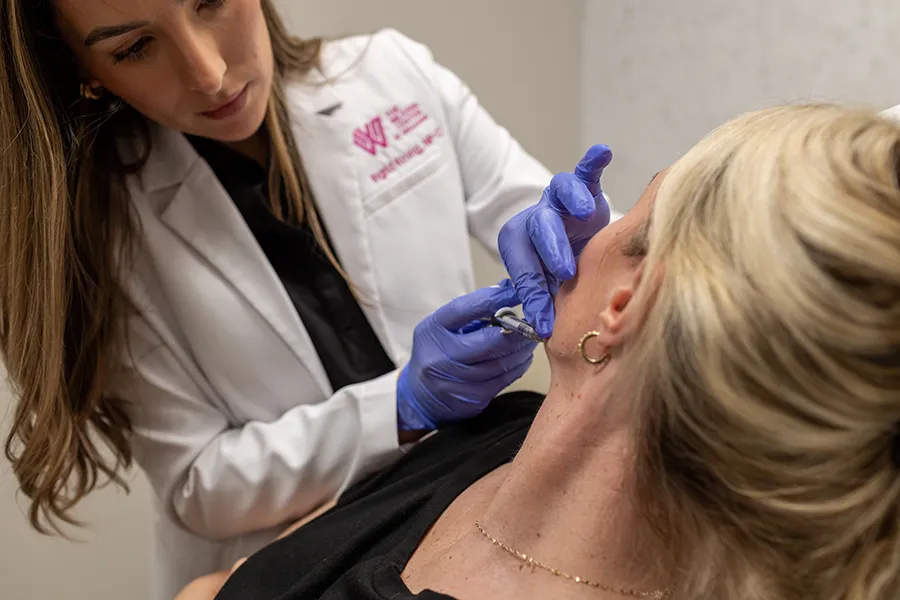 Woman patient receiving Juvéderm injectable filler in her jawline. 