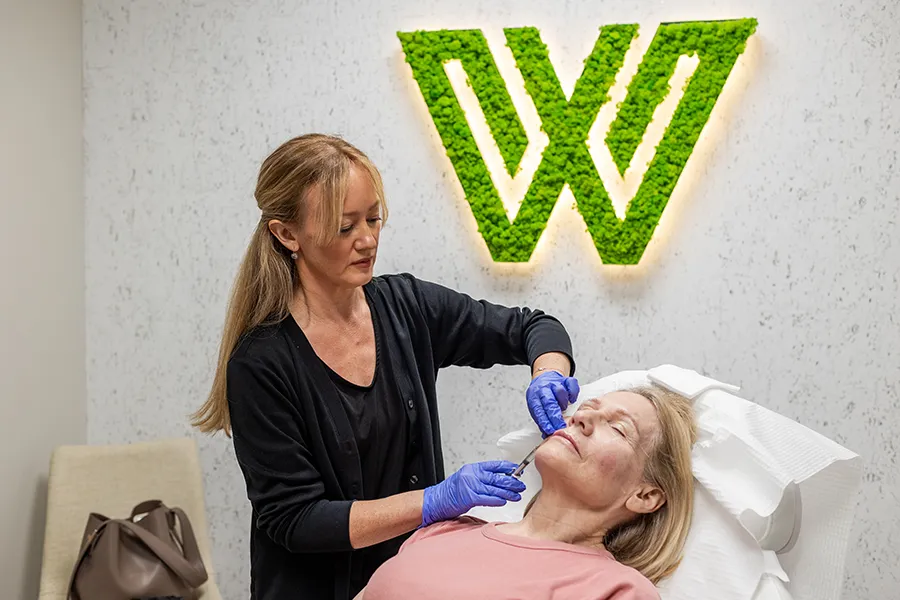 Older woman receiving Restylane injectable filler in her jawline and cheeks. 