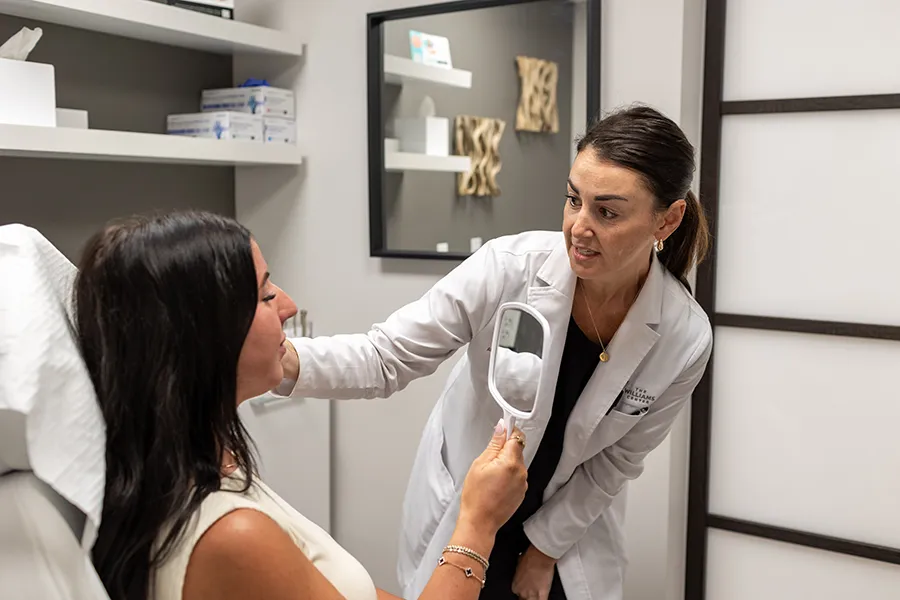 Young woman patient receiving a consultation for filler treatment placement. 