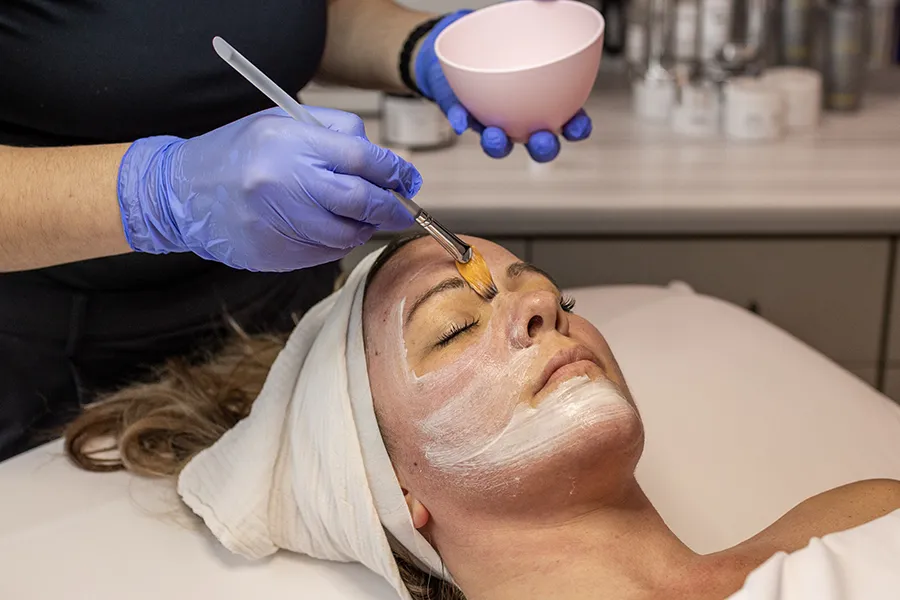 Young woman receiving a custom peel on her face. 