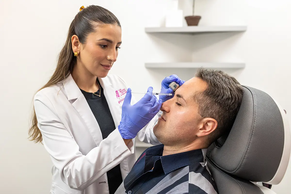 Middle-aged man receiving injectable Botox treatment in his forehead, treating horizontal forehead lines. 