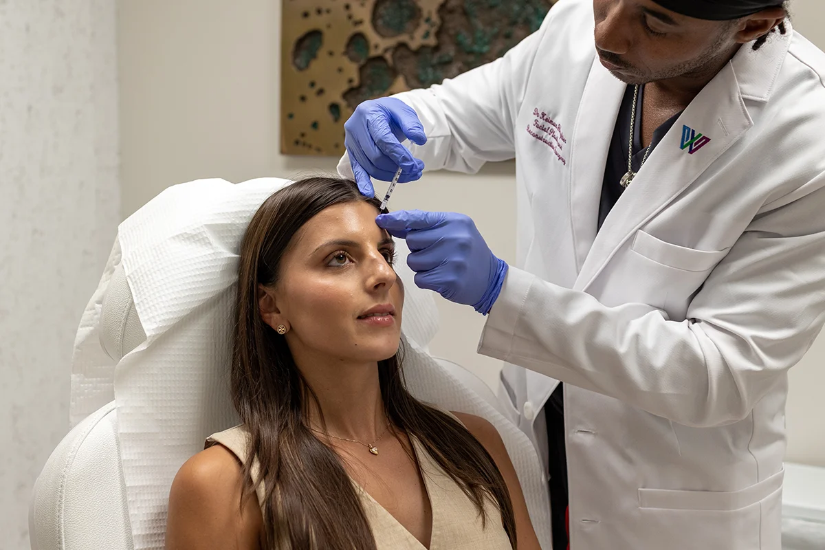 Young woman receiving injectable Xeomin treatment in her forehead. 