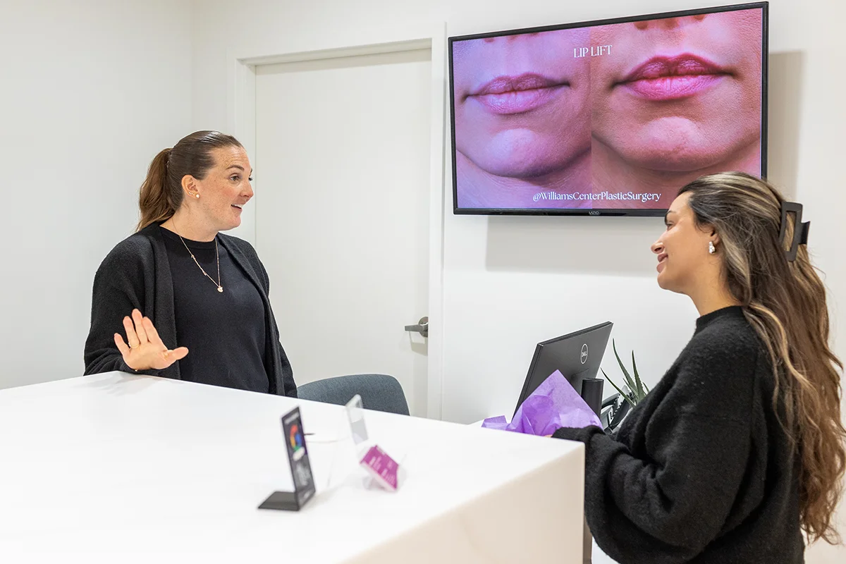 Young woman speaking with front desk manager at the Rejuva Center in Saratoga Springs, NY. 