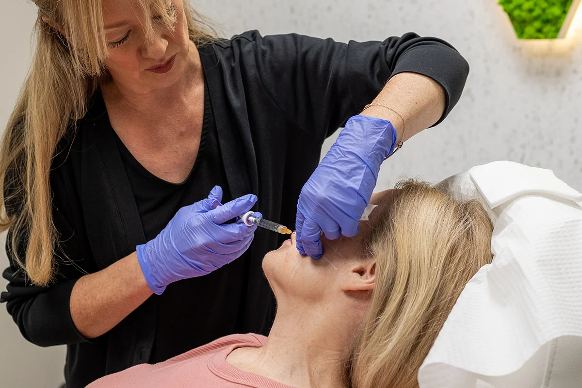 Older woman receiving injectable dermal filler in her nasolabial folds. 