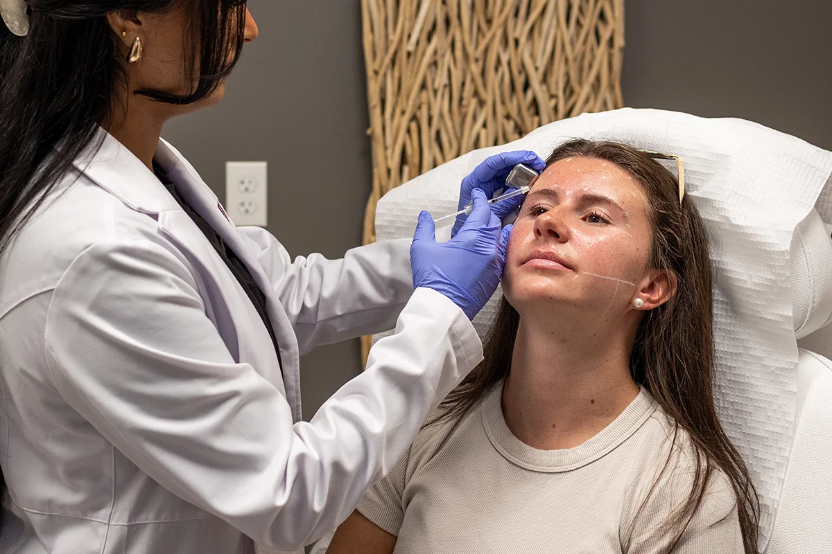 Young woman receiving injectable Dysport treatment in her forehead. 