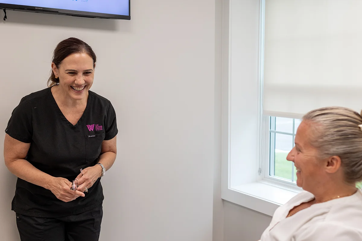 Older woman and provider Lisa LeBlanc having a consultation, chatting and laughing together. 