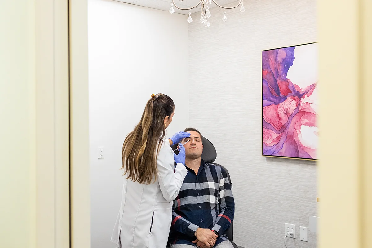 Middle-aged man receiving injectable dermal filler in his forehead to treat forehead lines. 