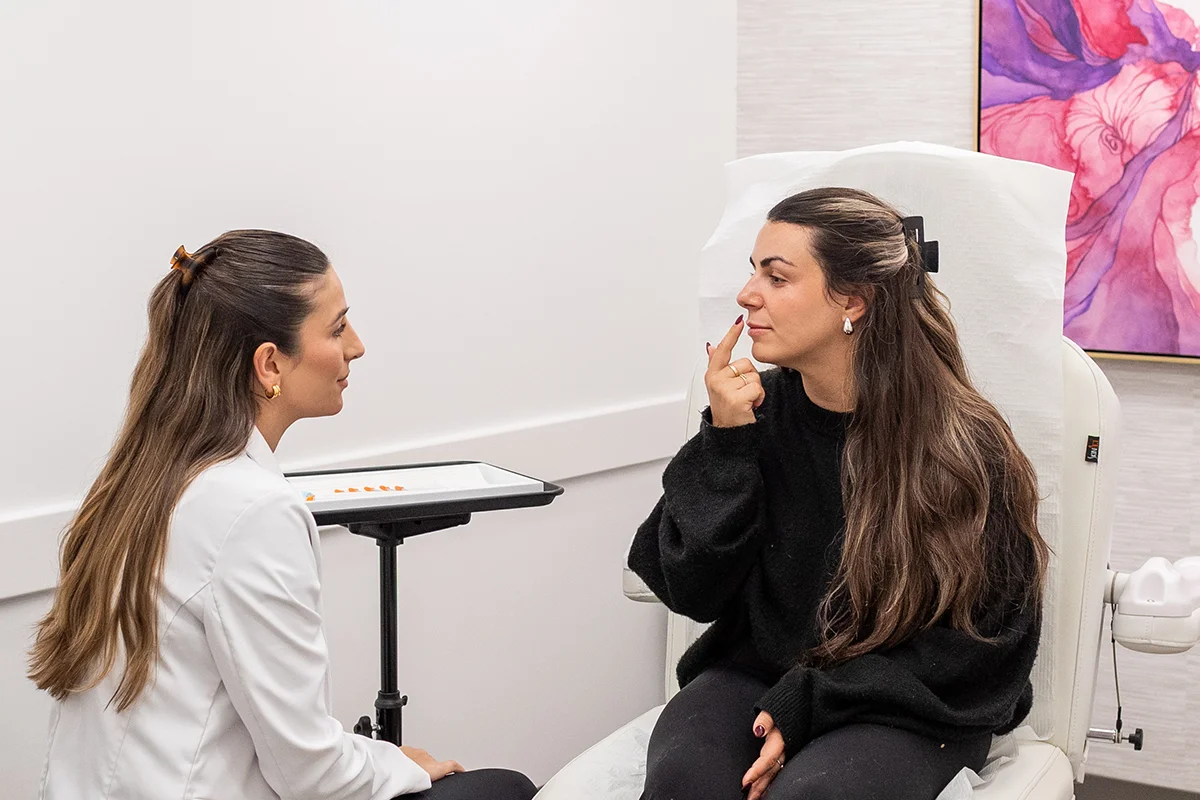 Young woman consulting with provider Ingrid Krong, pointing to her lip volume concerns. 