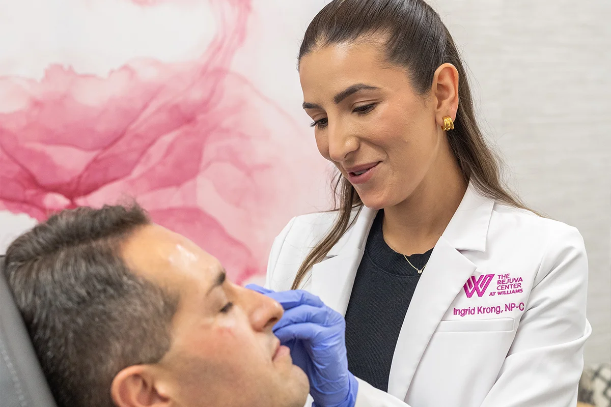 Middle-aged man receiving injectable dermal filler in his cheek for volume restoration and a subtle lift. 