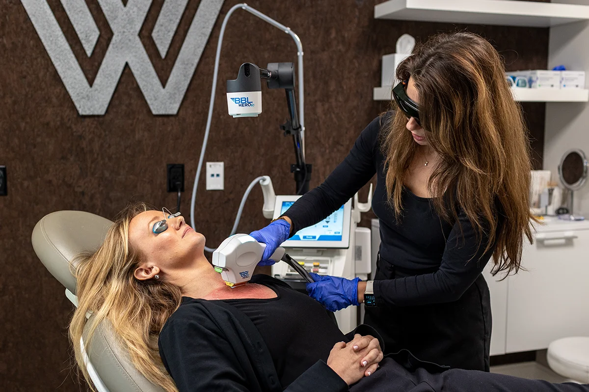 Middle-aged woman receiving BBL® HERO therapy on her décolleté area. 