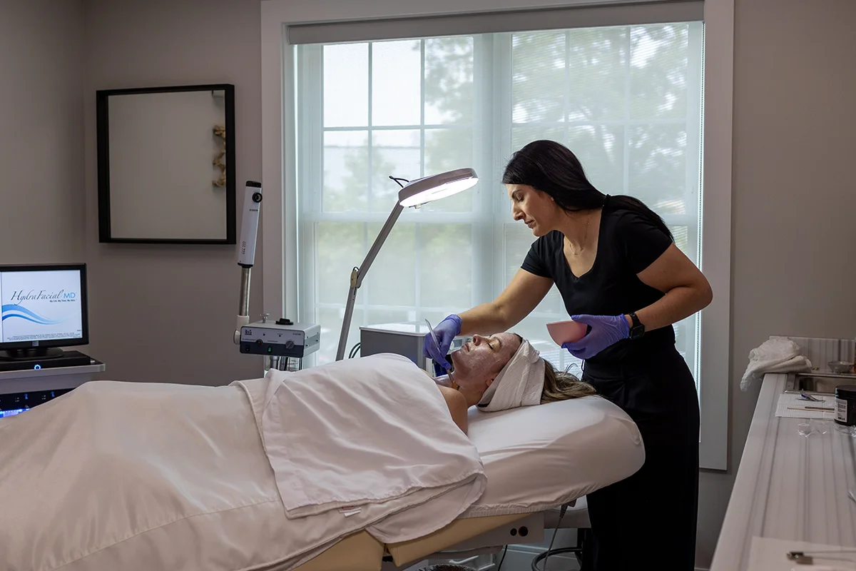 Young woman receiving a TCA chemical peel treatment on her face and neck. 