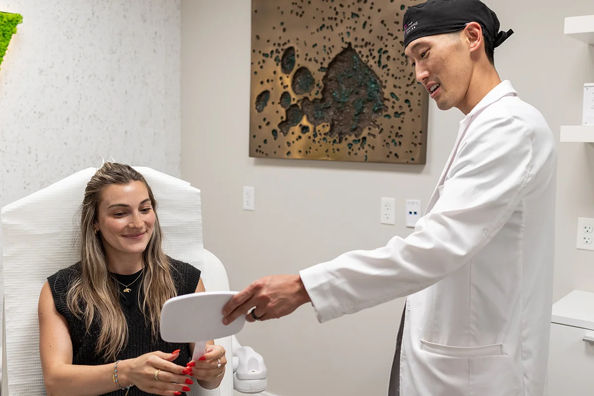Young woman consulting with Dr. Daniel Lee in a treatment room. 