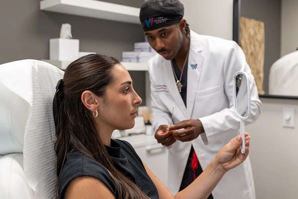 Young woman consulting with Dr. Keimun Slaughter in a treatment room. 