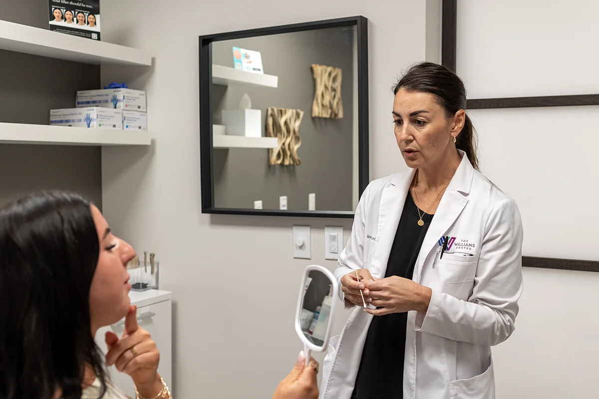 Young woman consulting with provider Andrea Lord, discussing concerns with her chin shape and submental fullness. 