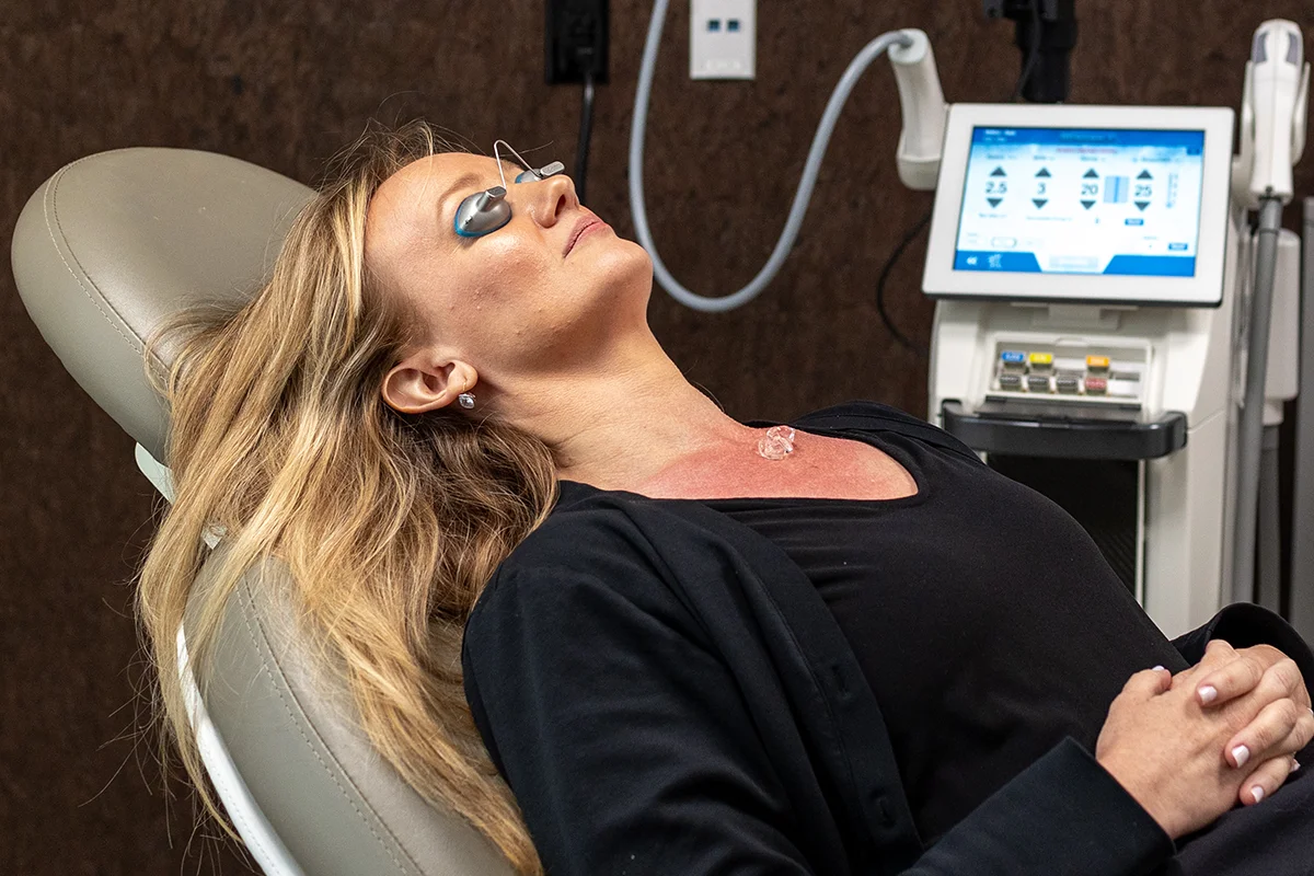 Middle-aged woman resting and waiting for laser treatment to saturate on her décolleté area. 