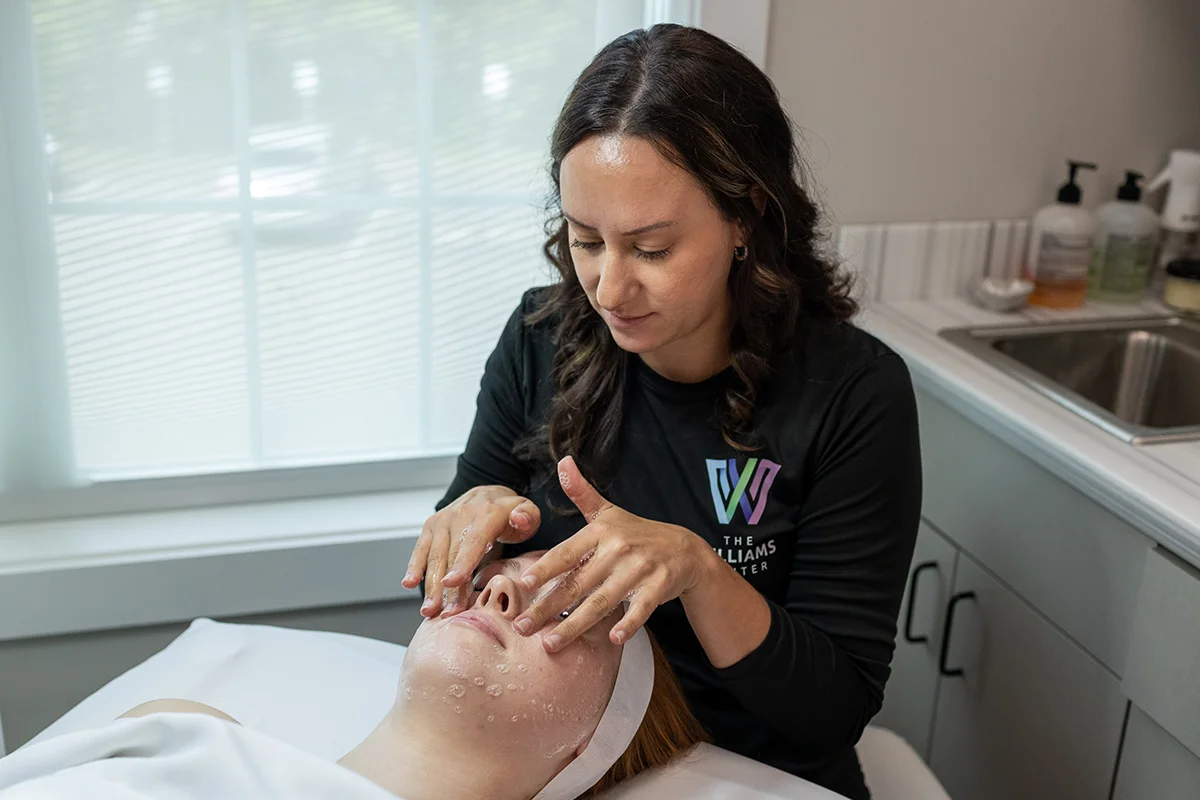 Young woman receiving a custom facial in a treatment room. 