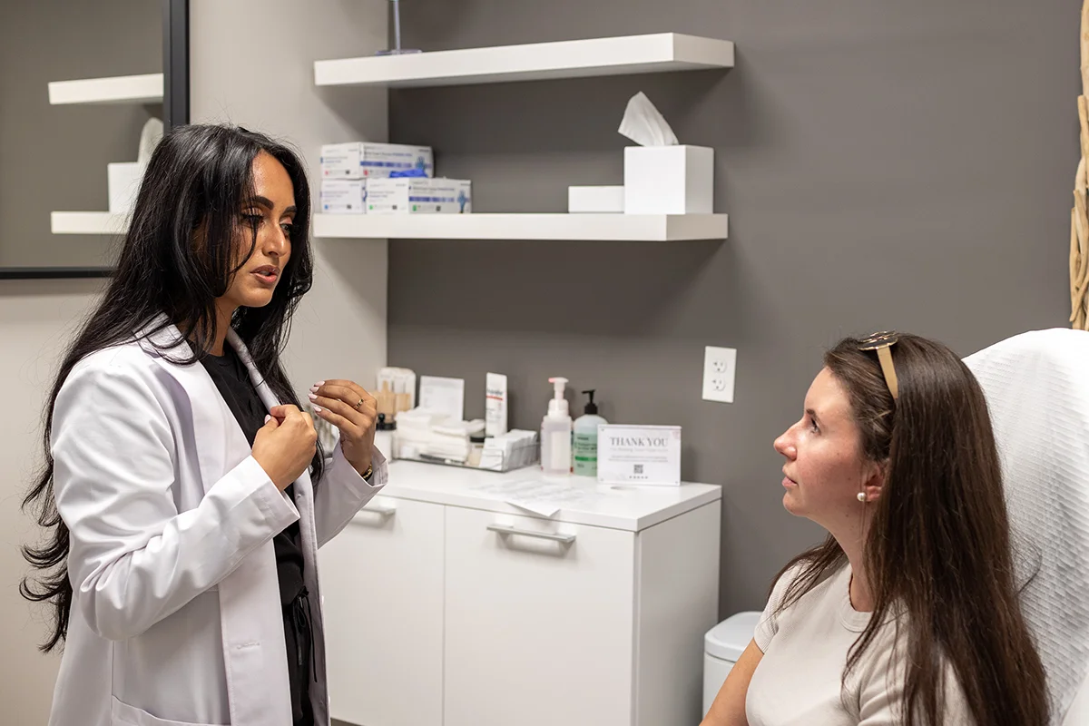 Young woman receiving a consultation from provider Seema Teymouri. 