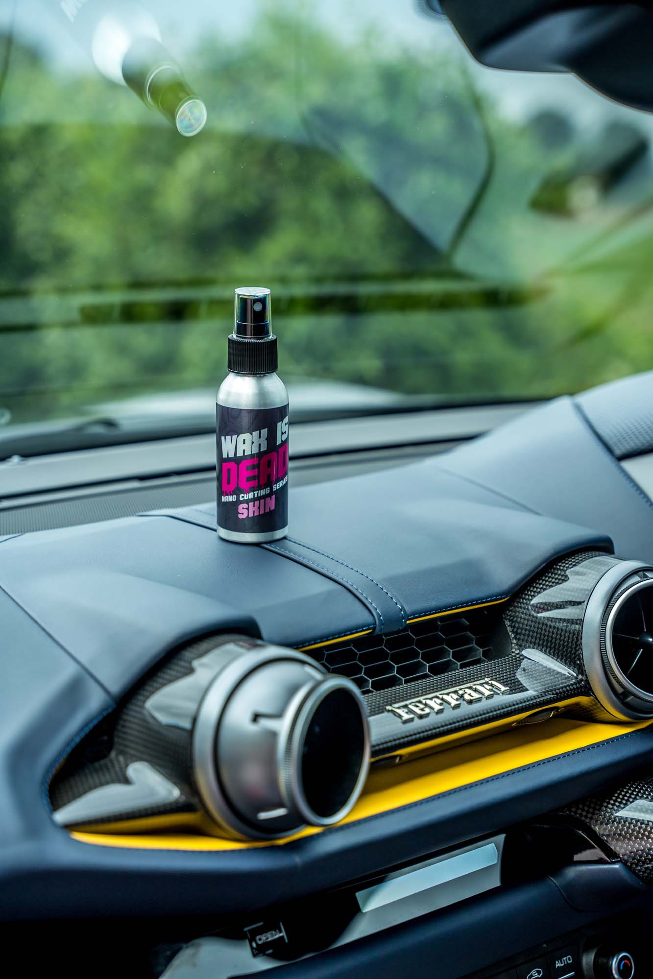 Wax Is Dead Skin trim coating bottle on a Ferrari dashboard