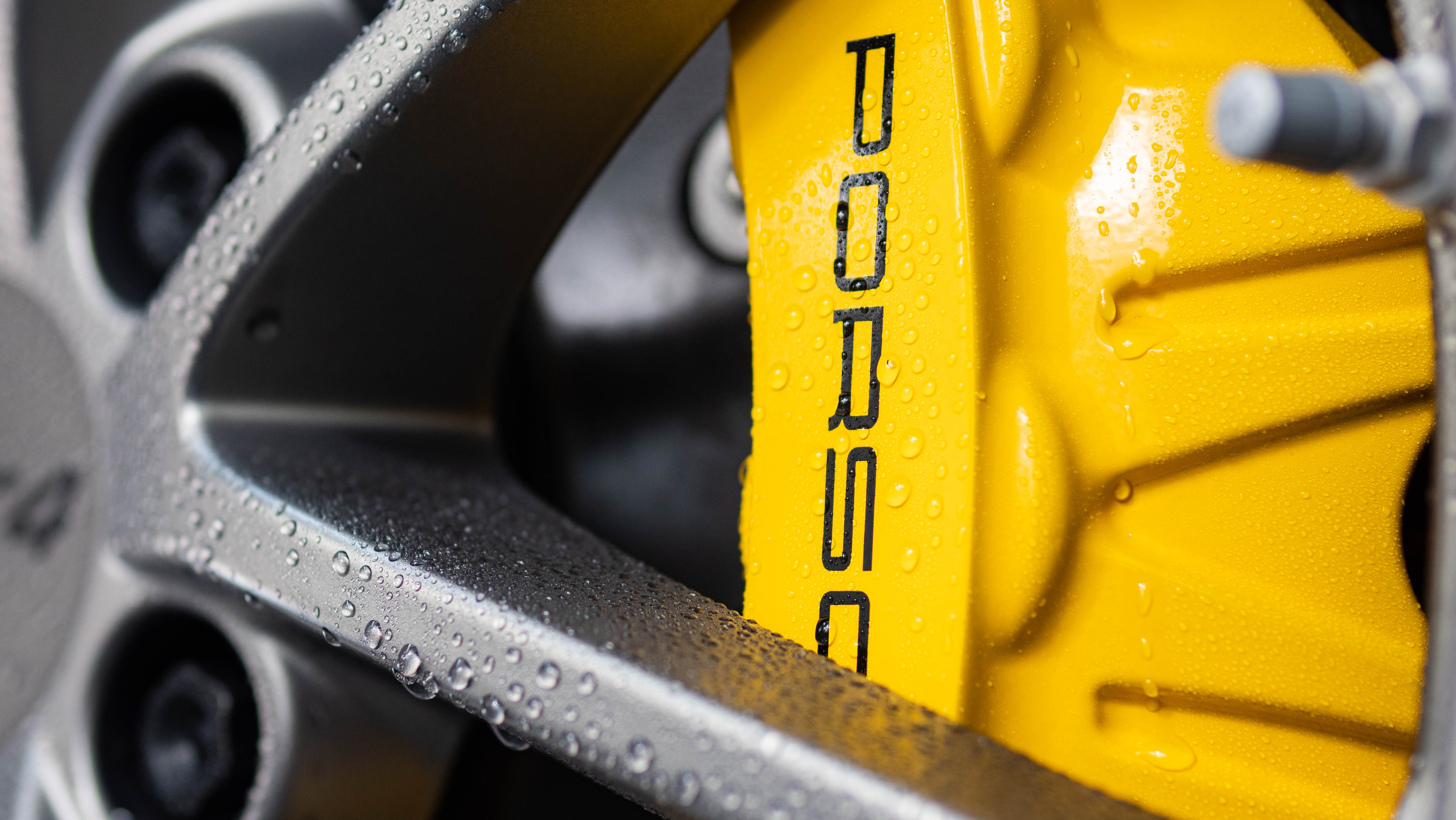 Water beading on a Porsche brake caliper after Wax Is Dead ceramic coating