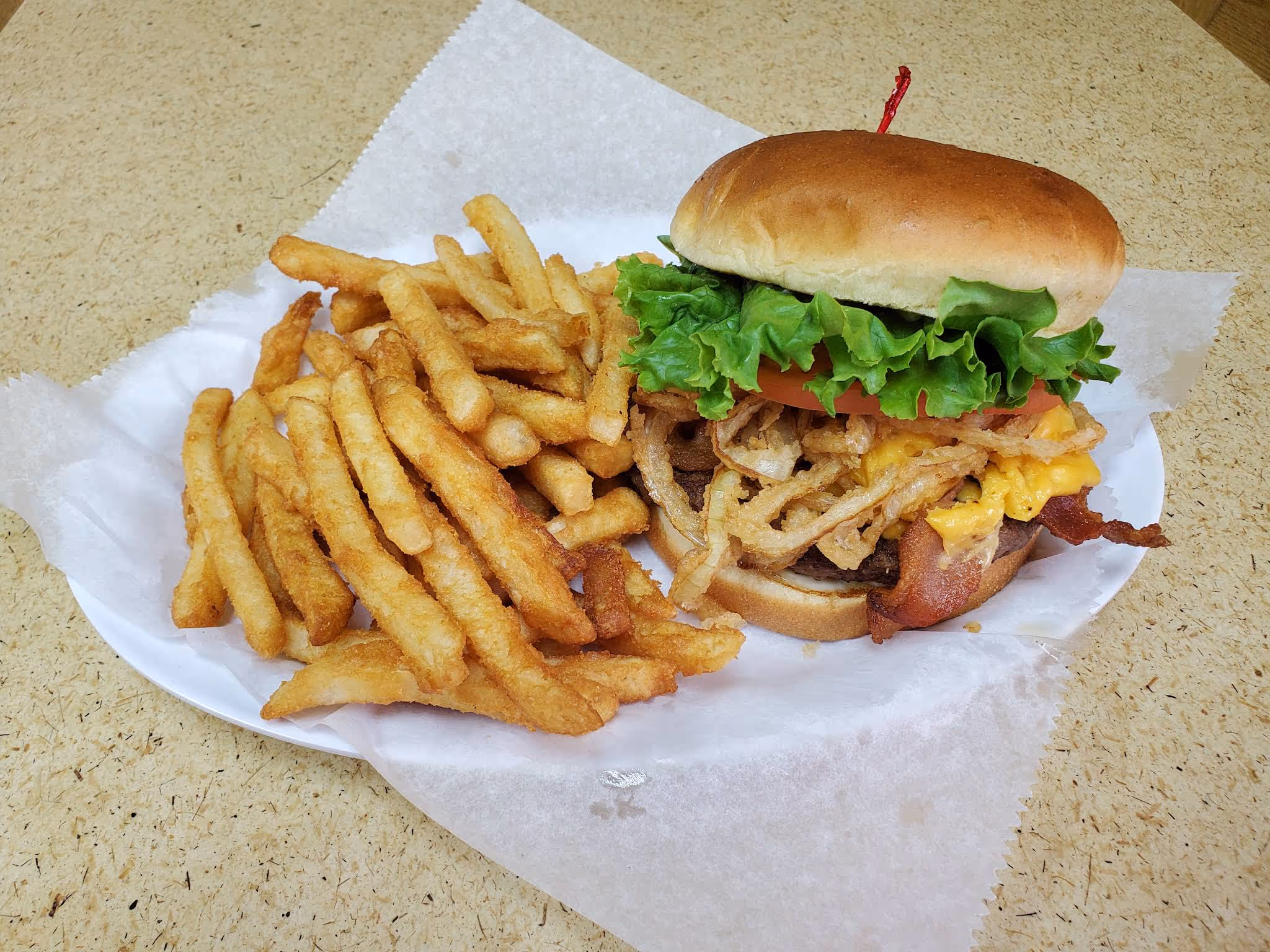 A sandwich with onions and tomatoes on a white plate.