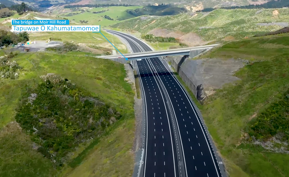 Overbridge crossing the new Ara Tūhono motorway at Moir Hill Road, known as Tapuwae O Kahumatamomoe, surrounded by rolling countryside.