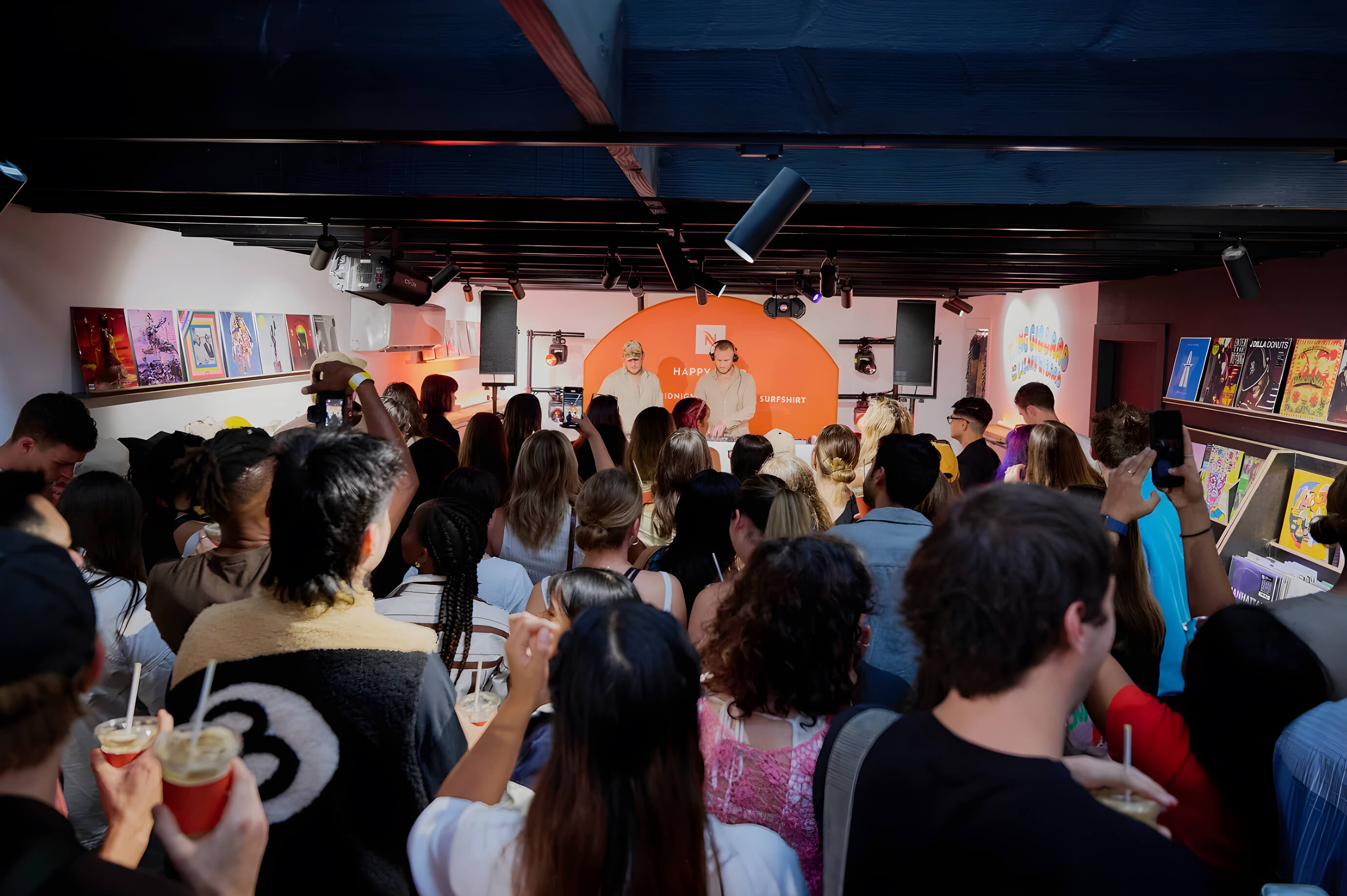 Audience gathered at the Nespresso Happy Hour event in Bondi, watching DJs perform under orange branded signage.