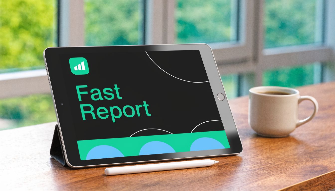 A tablet on a wooden desk displaying the Fast Report application logo, next to a coffee mug.