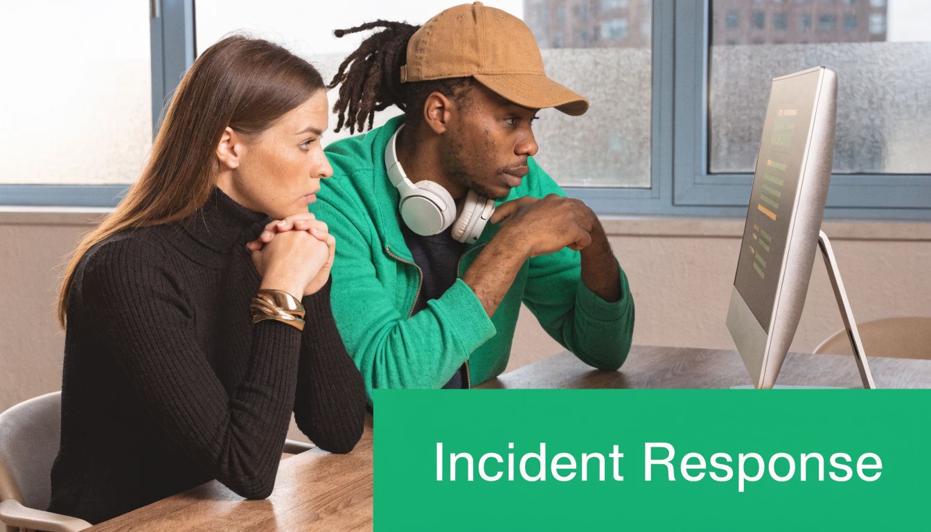 A woman and a man in a green jacket looking at a computer screen during incident response.
