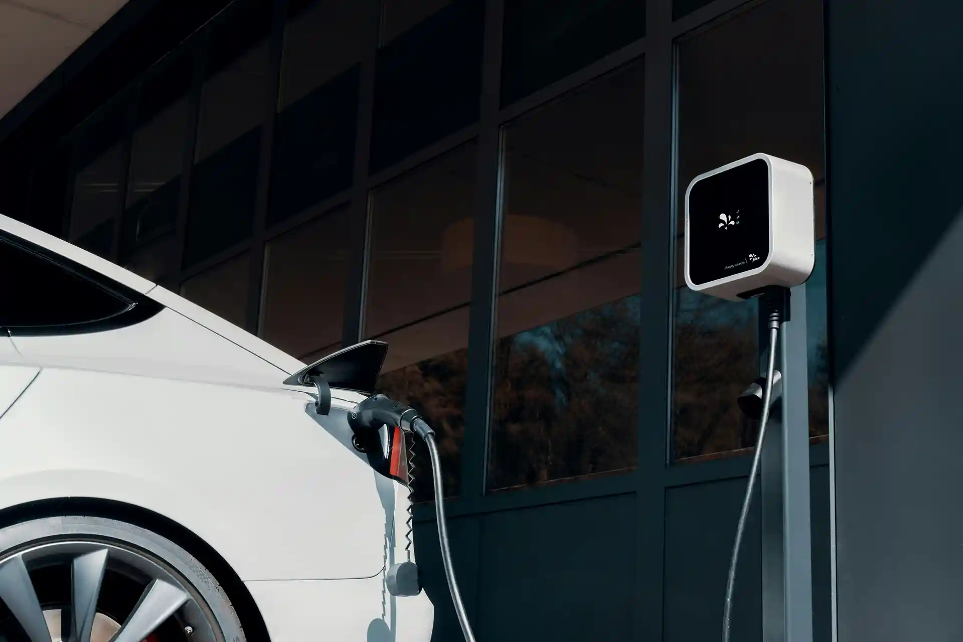 A cropped image showing the back section of a modern electric vehicle being charged