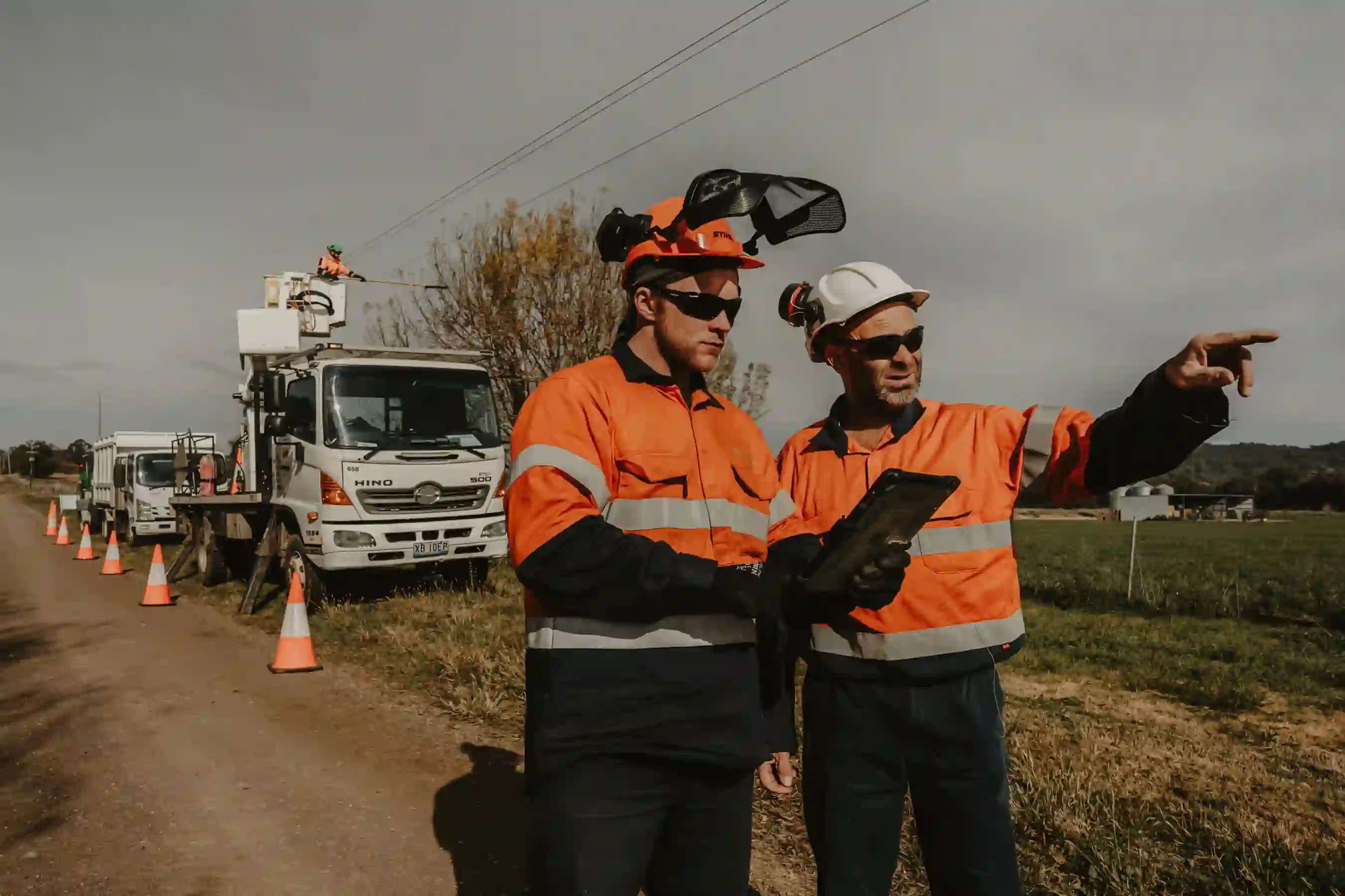 A couple of men standing next to each other on a dirt road.