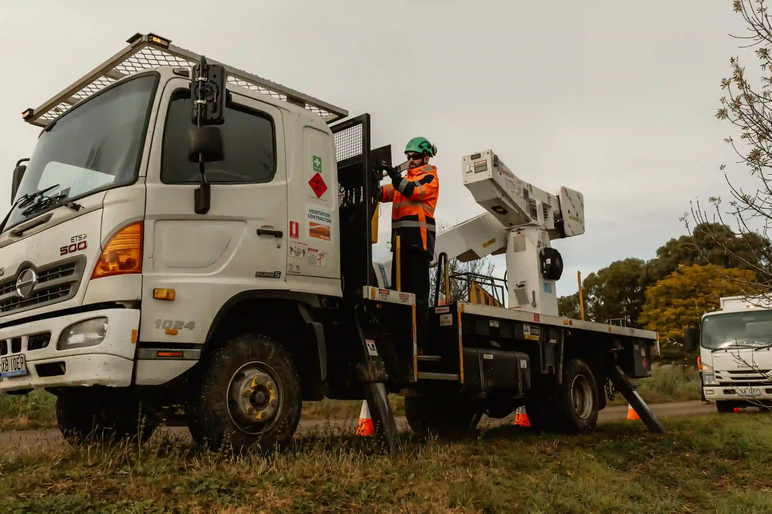 A man standing on the back of a white truck.