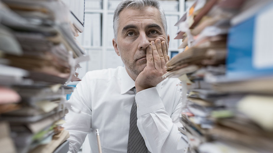 Drowning in Documents: A business owner overwhelmed by endless stacks of paperwork, illustrating the hidden challenges of entrepreneurship.