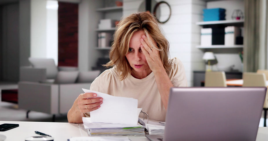 An overwhelmed business owner pouring over business invoices and receipts