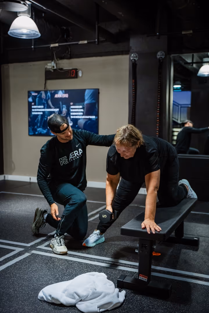 PT time med coach Joachim, dame som lærer roing med dumbbell.