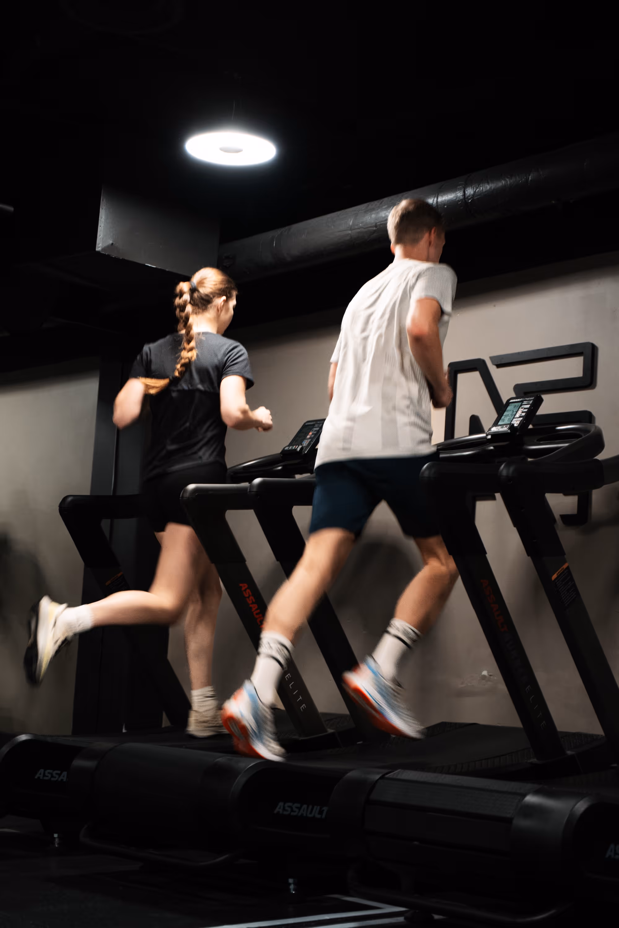 To medlemmer løper på tredemølle under gruppetrening hos Æra Training i Oslo.