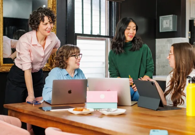 Marketing team meeting to compare GrowthAssistant vs. MarketerHire hiring options.