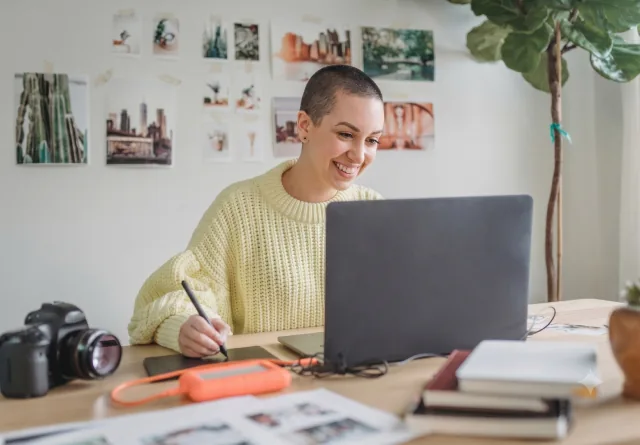 Woman smiling while filling out a team get-to-know-you survey at her desk.