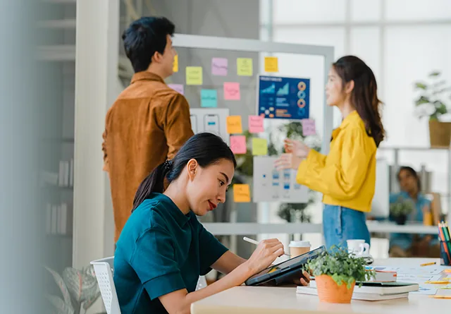 Team brainstorming interview questions for offshore marketing talent on a sticky-note board.
