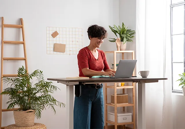 Woman smiling while researching marketing recruitment agencies at her desk.