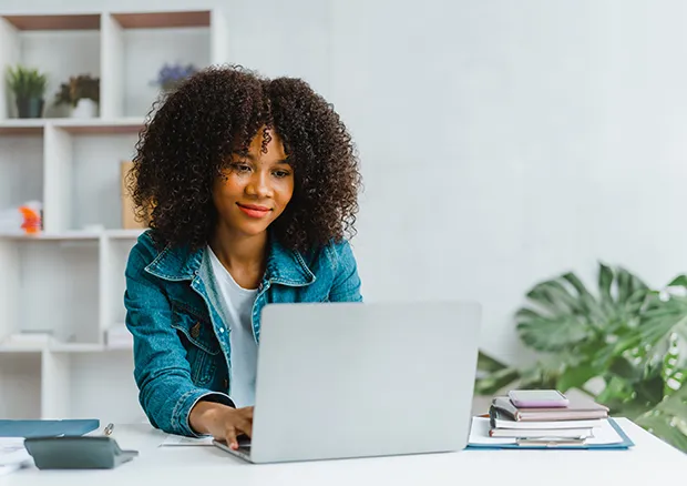 Teen female using her home laptop and smiling. 