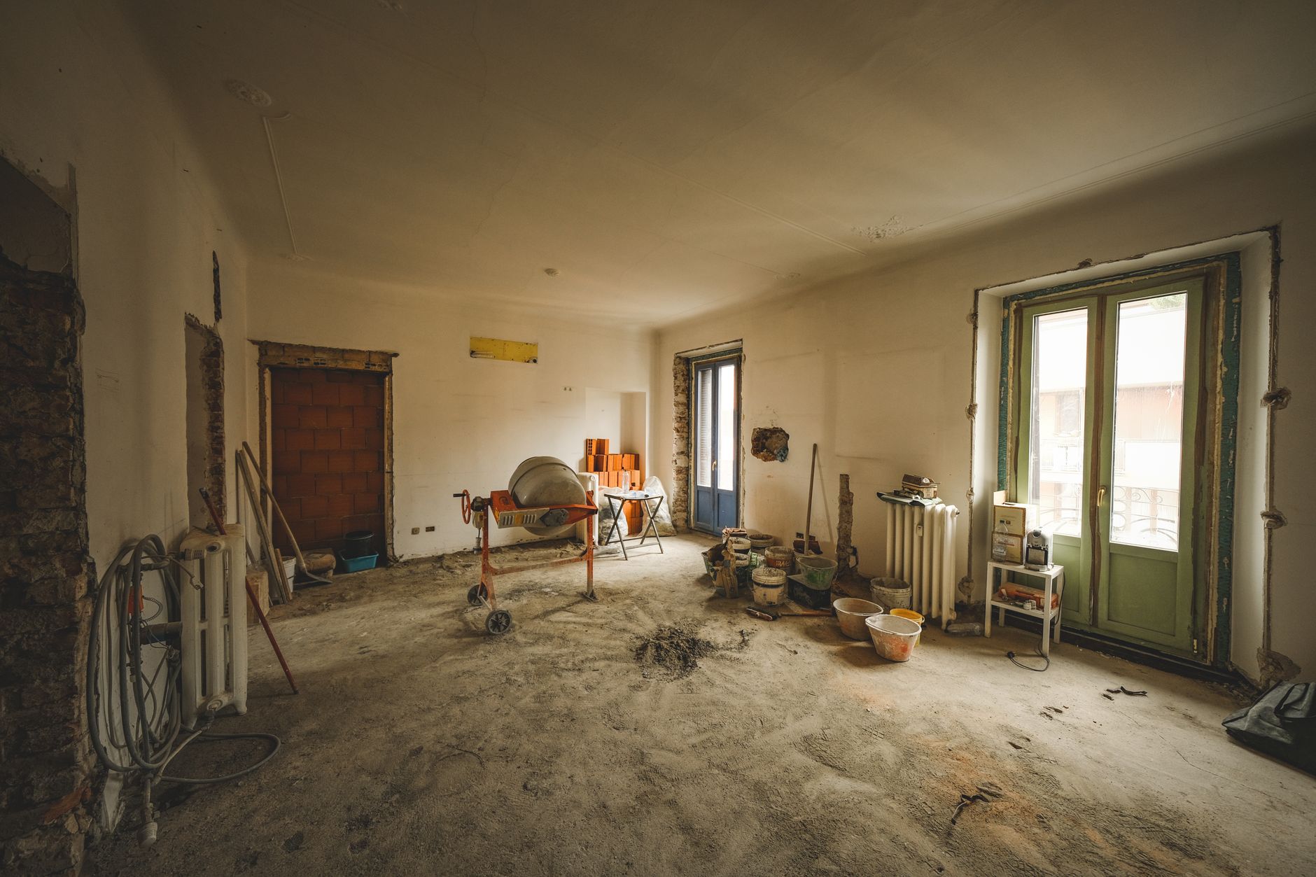 Stanza di una casa in ristrutturazione, con betoniera e materiali da cantiere