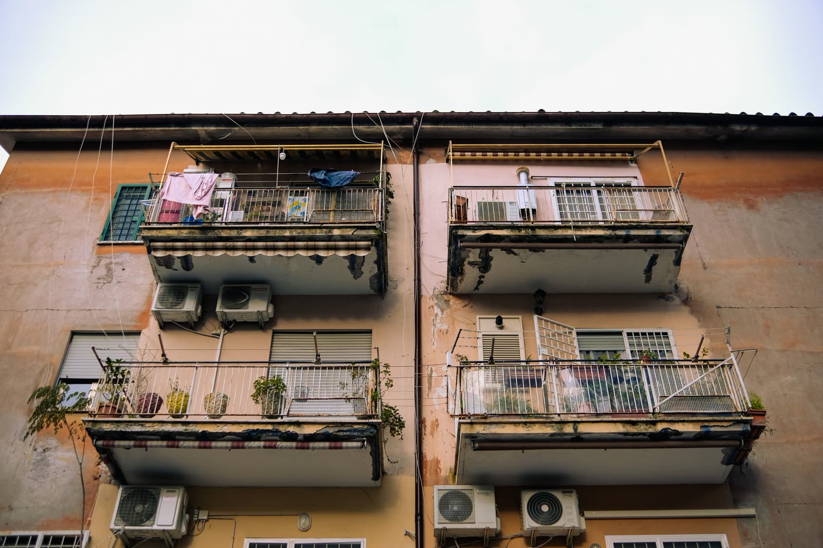 Facciata di un condominio degli anni del boom con balconi, persiane e condizionatori