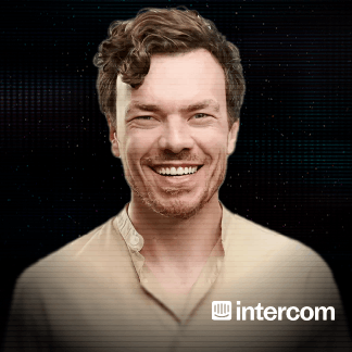 Portrait of a man with medium-length dark hair and a beard wearing a dark jacket against a black background with the HubSpot logo.