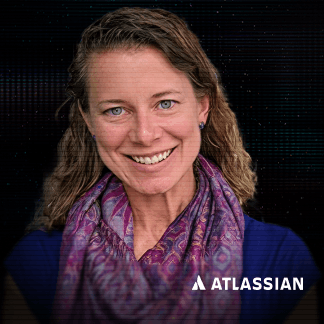 Man with dreadlocks and glasses wearing a black hoodie against a dark, digital background.
